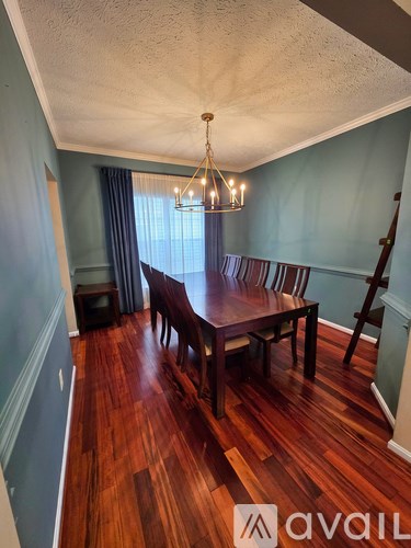 A dining room with a wooden table and chairs.