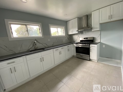A kitchen with white cabinets and a marble countertop.