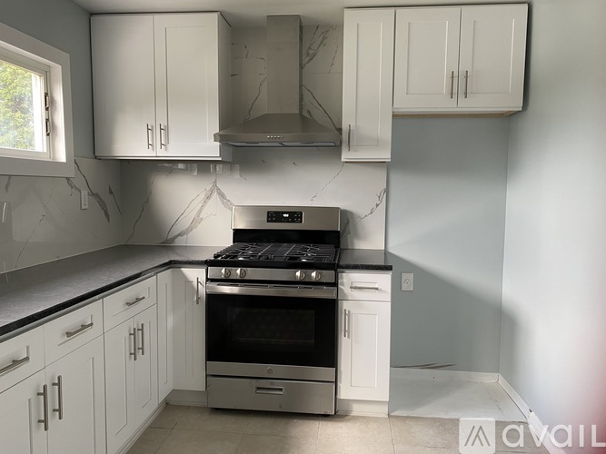 A kitchen with white cabinets and a black stove top oven.