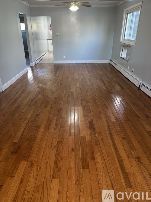 A room with wooden flooring and a ceiling fan.