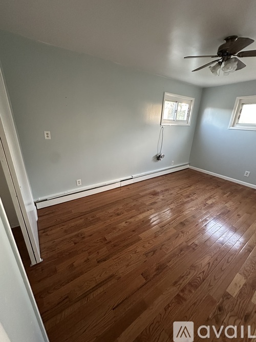 A room with wooden flooring and a ceiling fan.