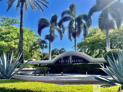 A sign that says "The Sterling" is in front of some trees.