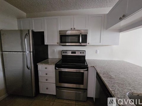 A kitchen with white cabinets and stainless steel appliances.