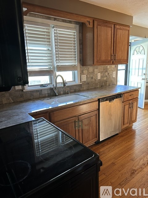 A kitchen with wooden cabinets and a black countertop.