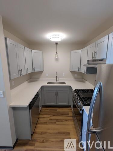 A kitchen with white cabinets and a wooden floor.