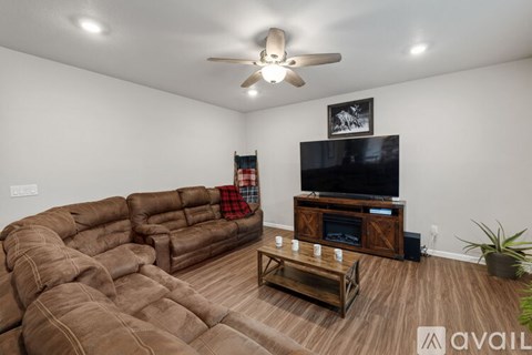 A living room with a brown couch and a flat screen TV.