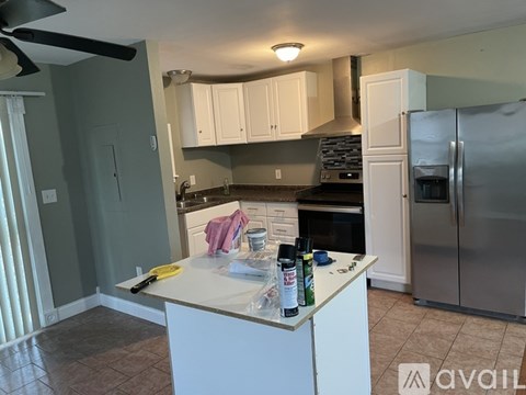 A kitchen with a white island and stainless steel appliances.