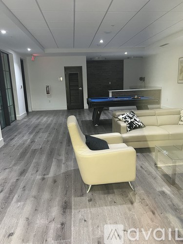 A living room with a pool table and a couch.