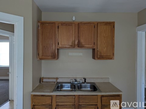 A kitchen with wooden cabinets and a double sink.