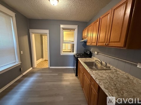 A kitchen with wooden cabinets and a marble countertop.