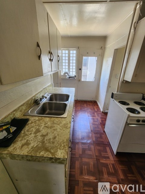 A kitchen with a sink and a stove top oven.