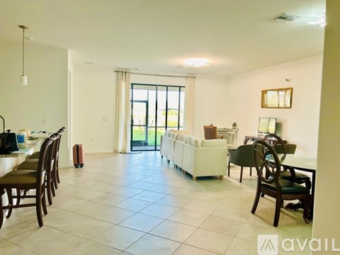 A spacious living room with a dining table and chairs.