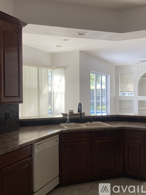 A kitchen with brown cabinets and a white dishwasher.