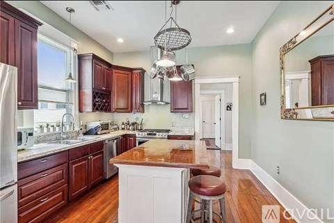 A kitchen with wooden cabinets and a white island.