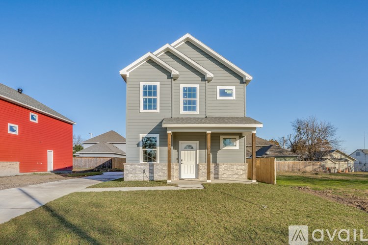 A house with a grey front and a red garage is available for sale.
