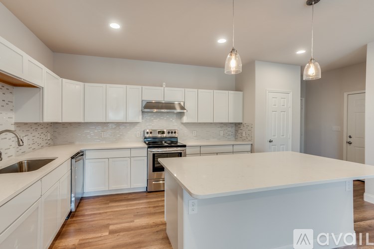 A kitchen with white cabinets and a large island.