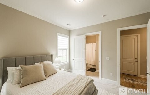 A bedroom with a large bed and a window.