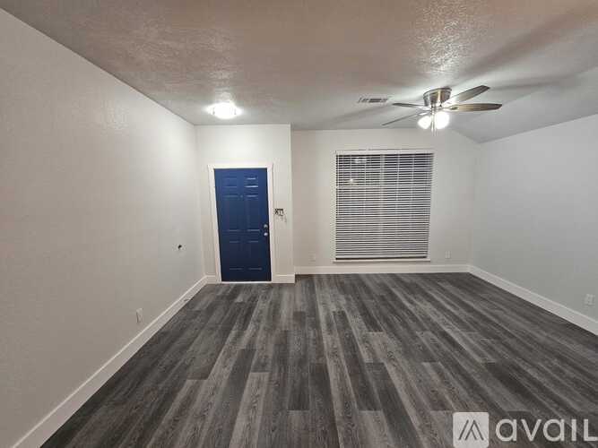 A room with a blue door and a window with blinds.