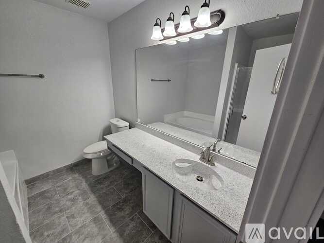 A bathroom with a toilet, sink, and mirror.