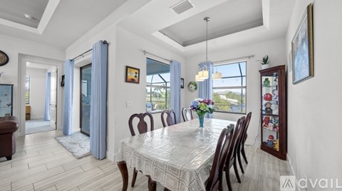 A dining room with a table set for six with a view of the backyard.
