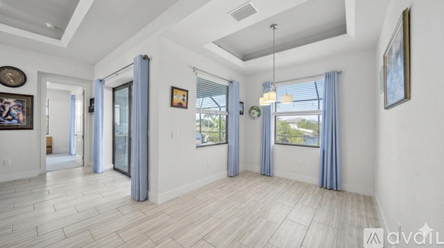 A spacious living room with a view of the outdoors through the windows.