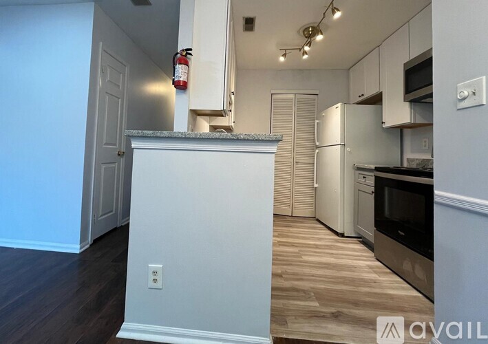 A kitchen with a white cabinet and a fire extinguisher on the wall.