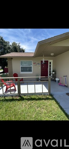 A house with a red door and a white fence.
