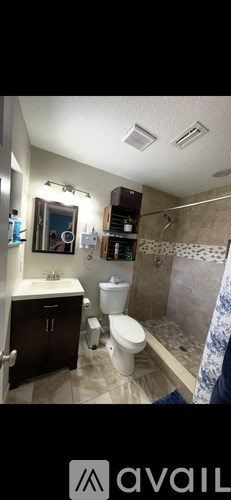 A bathroom with a toilet, sink, and mirror.