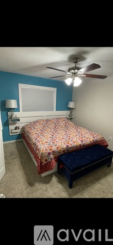 A bedroom with a bed and a ceiling fan.