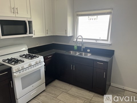 A kitchen with a white stove and black countertops.