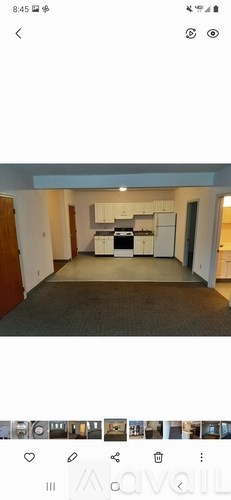 A room with a kitchenette and a refrigerator.