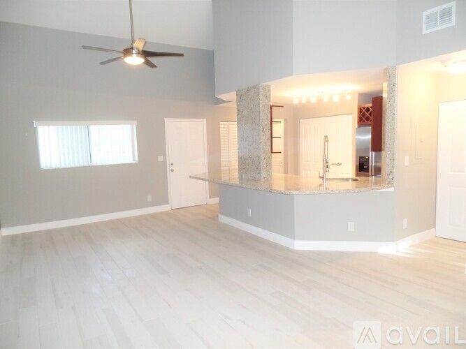 A spacious room with a ceiling fan and a large mirror on the wall.