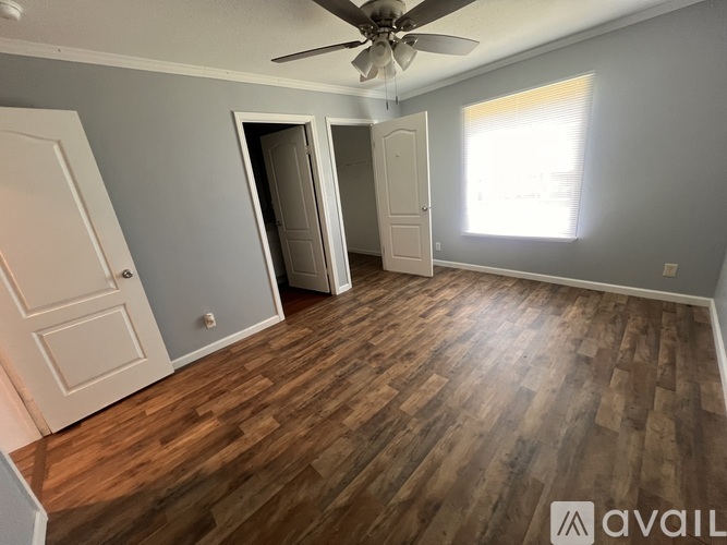 A room with wooden flooring and a ceiling fan.