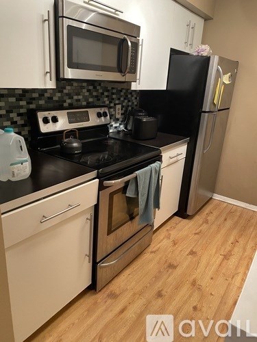 A kitchen with white cabinets and a black stove top.