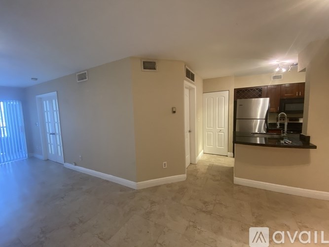A spacious living area with a kitchenette in the background.