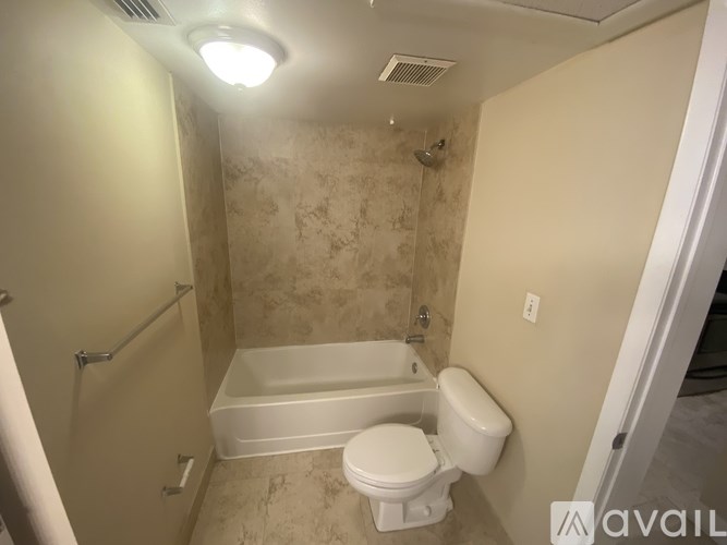 A small bathroom with a toilet, tub, and shower.