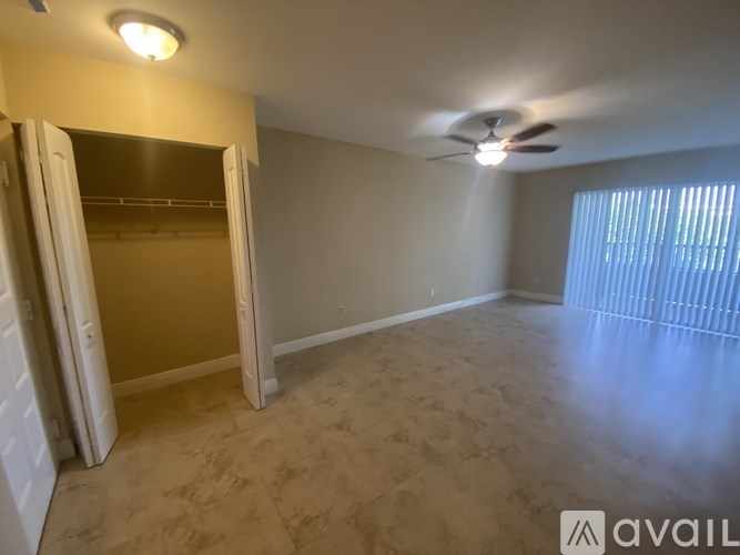 A room with a ceiling fan and a doorway leading to another room.