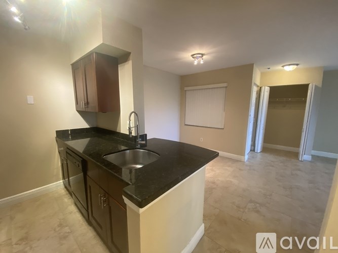 A kitchen with a black countertop and brown cabinets.