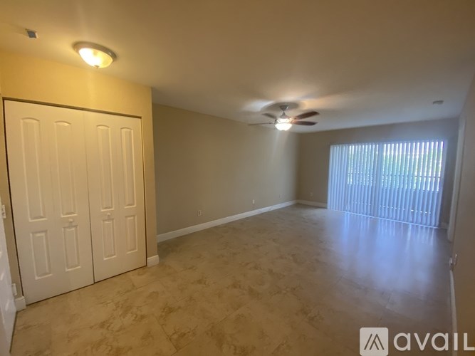 A room with a ceiling fan and a window with blinds.