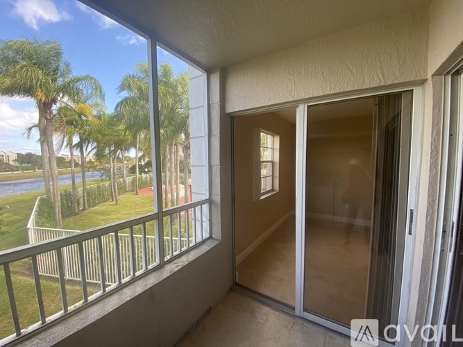 A balcony with a view of a body of water and palm trees.