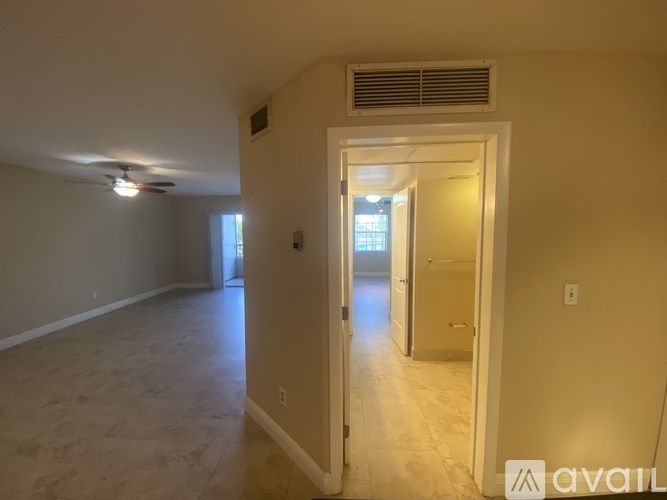 A room with a carpeted floor and a ceiling fan.