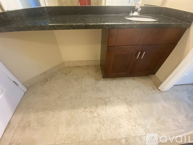 A kitchen with a marble countertop and tiled floor.