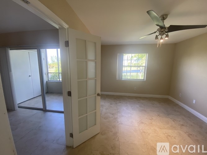 A room with a ceiling fan and a window.