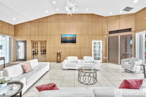 A living room with a white couch, a coffee table, and a painting on the wall.