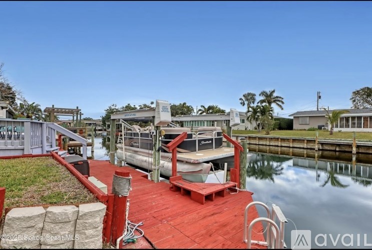 A red dock with a boat tied to it.