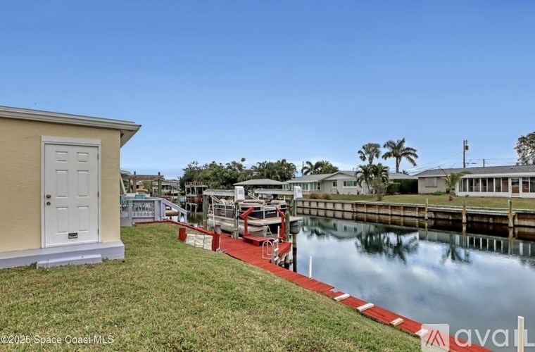A house with a white door is situated next to a body of water.