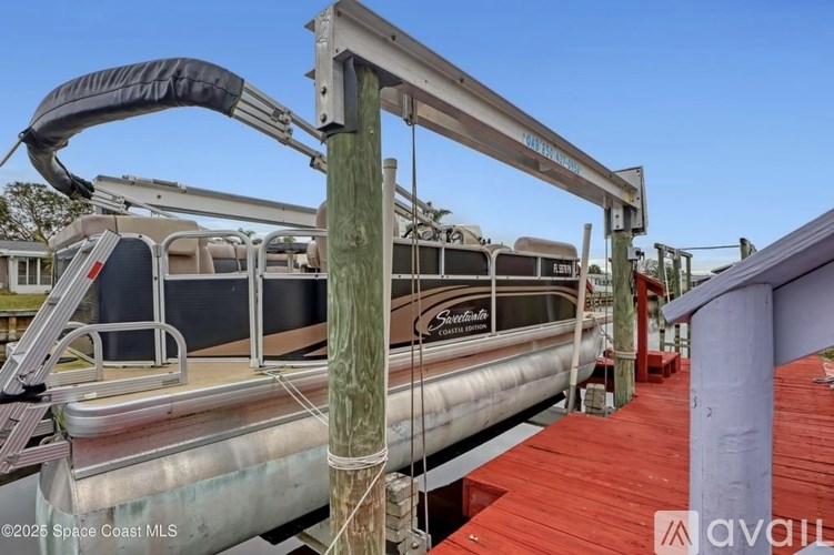 A boat is being lifted by a crane on a wooden dock.
