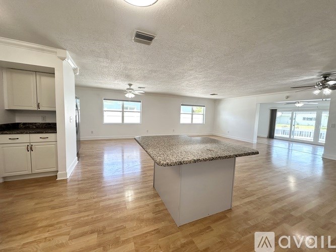 A room with a ceiling fan and sliding glass doors that lead to a patio.