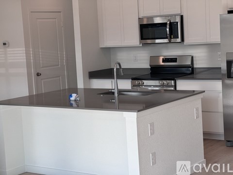 A modern kitchen with white cabinets and stainless steel appliances.