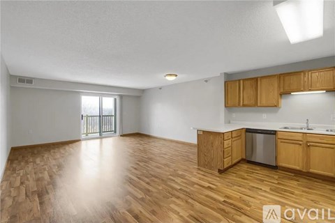 A spacious kitchen with wooden cabinets and a stainless steel dishwasher.